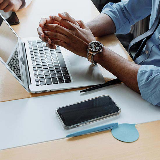 a man sitting at a desk with a laptop and a phone